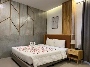 a bedroom with a large bed with red flowers on it at Hotel Halo in Angeles