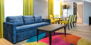 a living room with a blue couch and a table at Thon Hotel Spectrum in Oslo