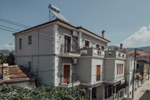 Un grand bâtiment blanc avec balcon se trouve dans une rue. dans l'établissement Guesthouse Sara & Esi, à Korçë