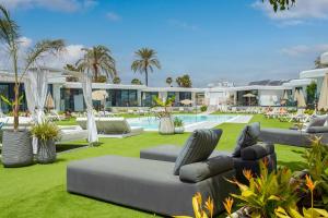 un patio del complejo con tumbonas y piscina en Bungalows Doña Rosa en Playa del Inglés