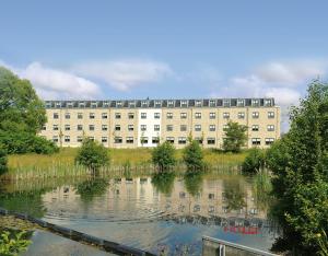 un edificio con un estanque delante de él en Hotel Quickborn & Gästehaus Hesse en Quickborn