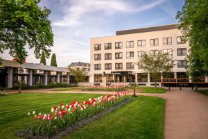 un edificio con tulipanes rojos y blancos delante de él en Hotel & Spa Chariclea en Poděbrady