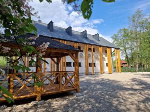 un gran edificio blanco con techo de gambrel en Skansen Forest en Liszki