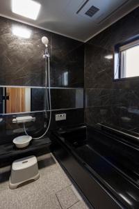 a bathroom with a shower and a toilet and a tub at TOKI NO YADO in Nakanogō