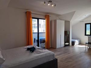 1 dormitorio con 1 cama con cortina naranja en Vila Lazri, en Shëngjin