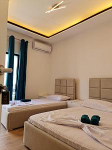 a bedroom with two beds and a ceiling at Vila Lazri in Shëngjin