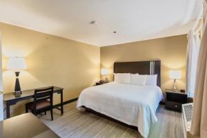 a hotel room with a bed and a desk and a chair at The Oakhurst Inn at Yosemite in Oakhurst