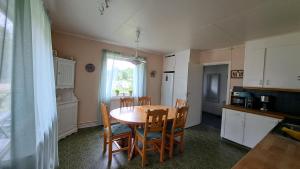 a kitchen with a table and chairs in a kitchen at Lilov in Sysslebäck