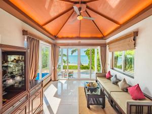 ein Wohnzimmer mit einem Sofa und einem Deckenventilator in der Unterkunft Sea Valley Resort in Lipa Noi