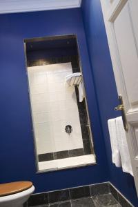 a bathroom with a toilet and a blue wall at Posada Real Casa de Tepa in Astorga