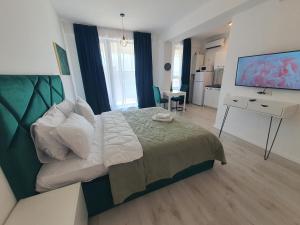 una camera con letto e scrivania con computer di Grey Residence Apartments a Tunarii