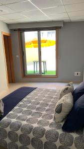 a room with a bed and a window with an umbrella at APARTAMENTO FONTE DO CRISTO in Porriño