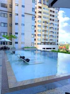 - une piscine avec deux bateaux au milieu d'un bâtiment dans l'établissement City View at The Persimmon Studios, à Cebu