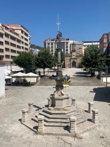 a fountain in a courtyard with a statue on it at APARTAMENTO FONTE DO CRISTO in Porriño