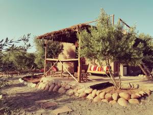 ein kleines Haus mit einer Bank davor in der Unterkunft Les Jardins de Taja in Ourika