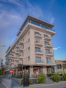 a tall apartment building on a city street at Hotel Bar Restaurant Triumf Shengjin in Shëngjin