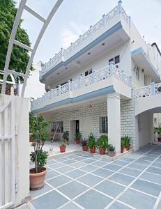 a white house with a balcony and potted plants at Madhav's Mallet in Jaipur