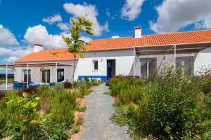 une maison blanche avec un toit orange dans l'établissement Monte do Pocinho, à São Domingos