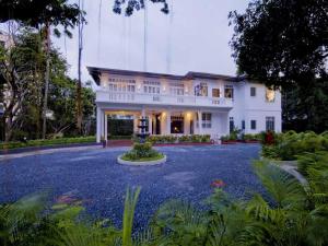 uma grande casa branca com uma grande entrada em The Henry Hotel Manila em Manila