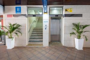 een gebouw met een trap en een deur met twee planten bij Hotel Las Américas in Málaga