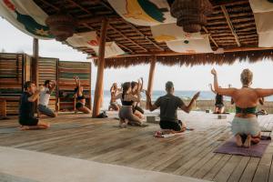 een groep mensen die yoga doen op het strand bij Selina Poc Na Isla Mujeres in Isla Mujeres