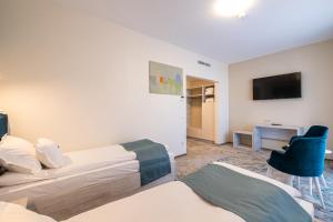 una camera d'albergo con due letti e una televisione di Fiald Hotel & Spa a Bacău