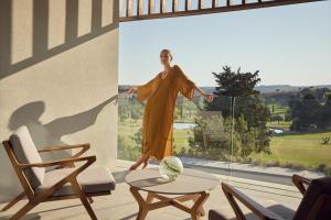 a man in a robe standing on a window at Minthis Resort in Paphos