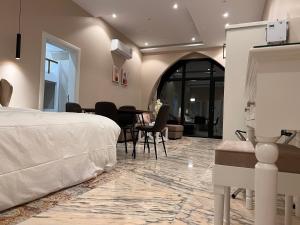 1 dormitorio con 1 cama, mesa y sillas en الأجنحة الرخامية فندقية, en Buraidah