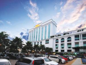 een groot wit gebouw met auto's geparkeerd op een parkeerplaats bij Berjaya Waterfront Hotel, Johor Bahru in Johor Bahru