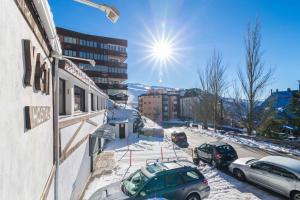 pokryta śniegiem ulica z samochodami zaparkowanymi po stronie budynku w obiekcie Hostal Yeti w mieście Sierra Nevada