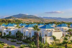 un gran edificio blanco con techos azules en Banyan Tree Tamouda Bay en Fnidek