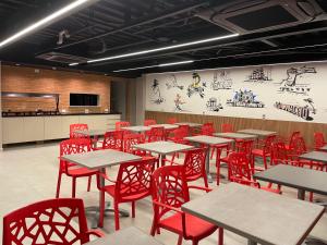 une salle à manger avec des tables et des chaises rouges dans l'établissement Saint Patrick Grand Hotel, à Maceió