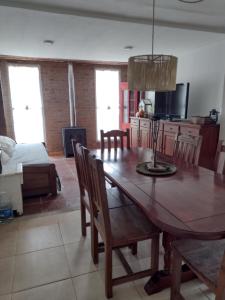 cocina y comedor con mesa de madera y sillas en Cabaña Rundun en Santa Catalina