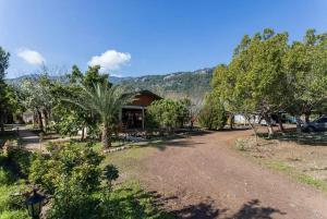 uma estrada de terra em frente a uma casa com árvores em Likya Yanartaş Bungalow em Kemer