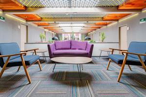 a waiting room with a purple couch and two chairs at Kali Ciudadela Mexico City in Mexico City