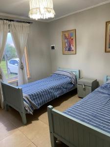 1 dormitorio con 2 camas y ventana en Cabaña Rundun en Santa Catalina