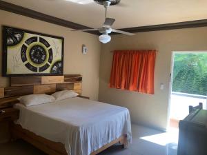 - une chambre avec un lit et un ventilateur de plafond dans l'établissement Hotel Cambri, à Nagua