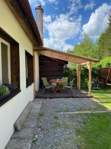 een patio met een tafel en stoelen onder een pergola bij Połoninka in Ustrzyki Górne