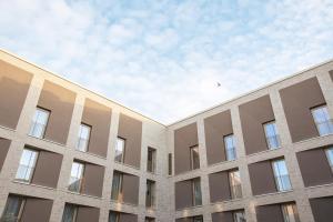 eine Fassade eines Gebäudes mit dem Himmel im Hintergrund in der Unterkunft Holiday Inn - the niu, Amity Potsdam, an IHG Hotel in Potsdam