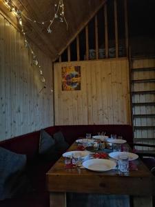 a wooden table with plates and glasses on it at Nice House in Maidan Village