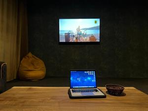- un ordinateur portable assis sur une table en bois et une télévision dans l'établissement Hotel Eden, à Mestia
