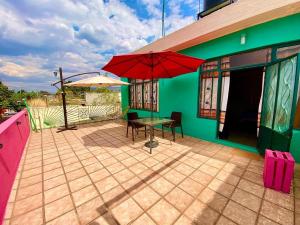 une terrasse avec une table et un parasol dans une maison dans l'établissement Hostal Mixteco Naba Nandoo, à Oaxaca