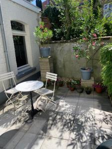 un patio con tavolo, sedie e piante in vaso di HS68-apartment a Maastricht