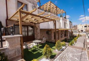 un patio con mesa y sillas en un edificio en Garden Suites Hotel Cappadocia en Goreme