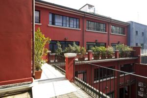 een rood gebouw met potplanten op de balkons bij Oasi Village Hotel in Milaan