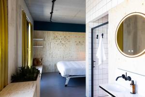 bagno con letto, lavandino e specchio di hotel Moloko -just a room- sleep&shower-digital key by SMS a Enschede