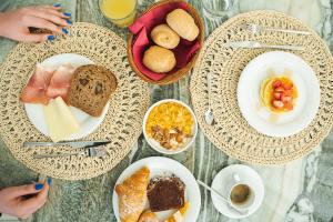 a table with plates of food and bowls of breakfast foods at Unique Hotel in Cesenatico