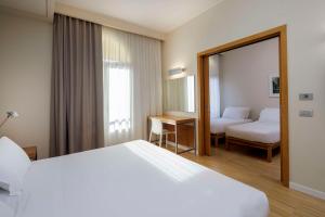 una camera d'albergo con letto e specchio di Best Western Plus Hotel Bologna a Mestre