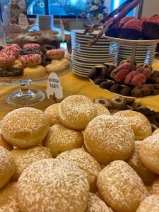 un montón de donuts y otros pasteles en una mesa en Hotel Vega Perugia en Perugia