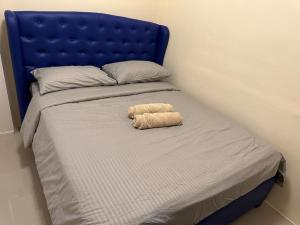 Una cama con una cabecera azul con un animal de peluche. en 4 Bedroom Bungalow, Angeles City en Ángeles